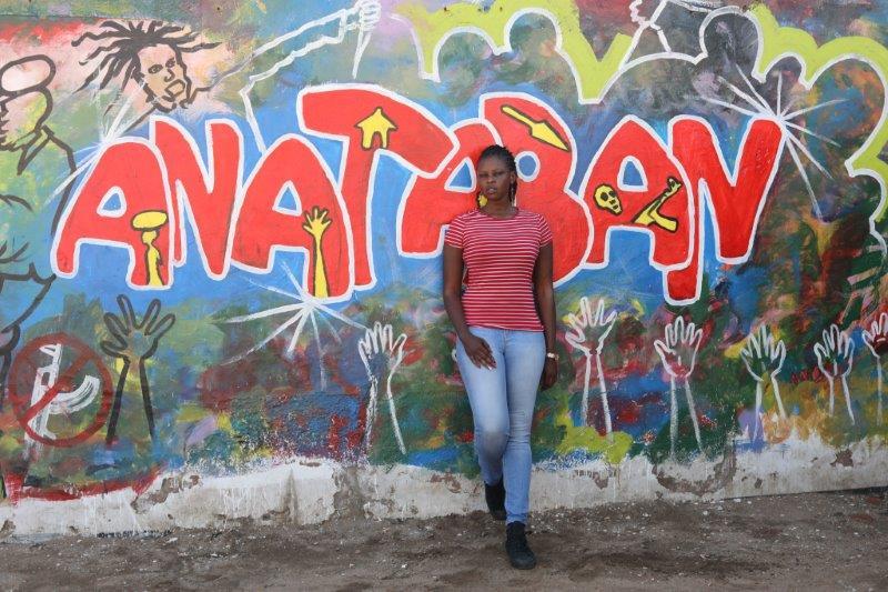 أياك كول دينغ ألق، 32، طبيبة وشاعرة، في وضع التقاط صورة لها أمام جدارية لحركة "أنا تعبان"، في جوبا، جنوب السودان، في 22 مارس 2018. مؤسسة طومسون رويترز.